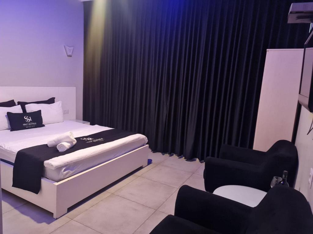 a bedroom with a bed and two chairs in it at אשדוד מול הים in Ashdod