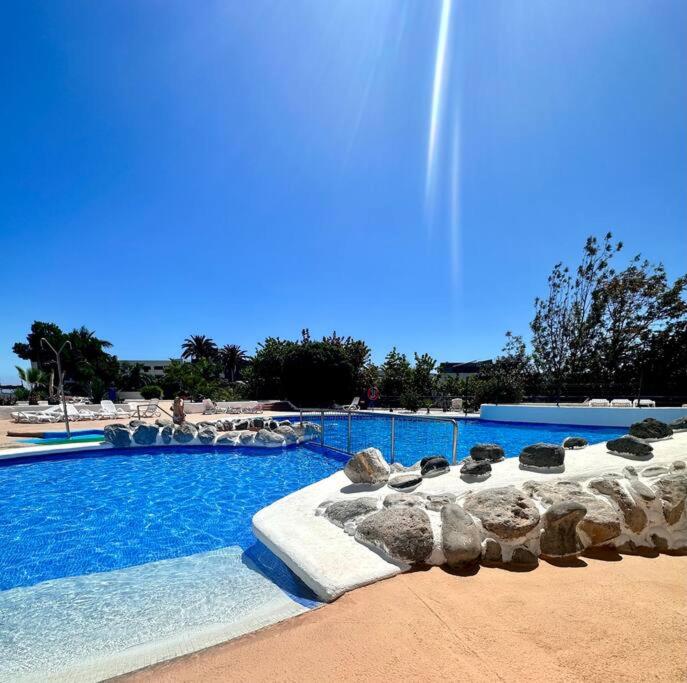 une grande piscine d'eau bleue et de rochers dans l'établissement Mirador Paraiso: Superb Sea View, à Playa Paraiso