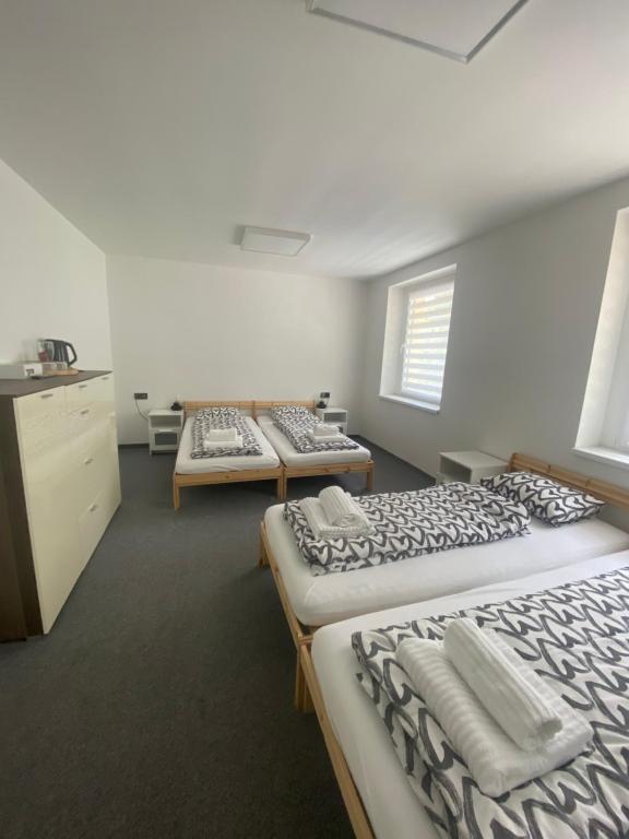 ein Zimmer mit drei Betten in der Reihe in der Unterkunft Penzion Puk 