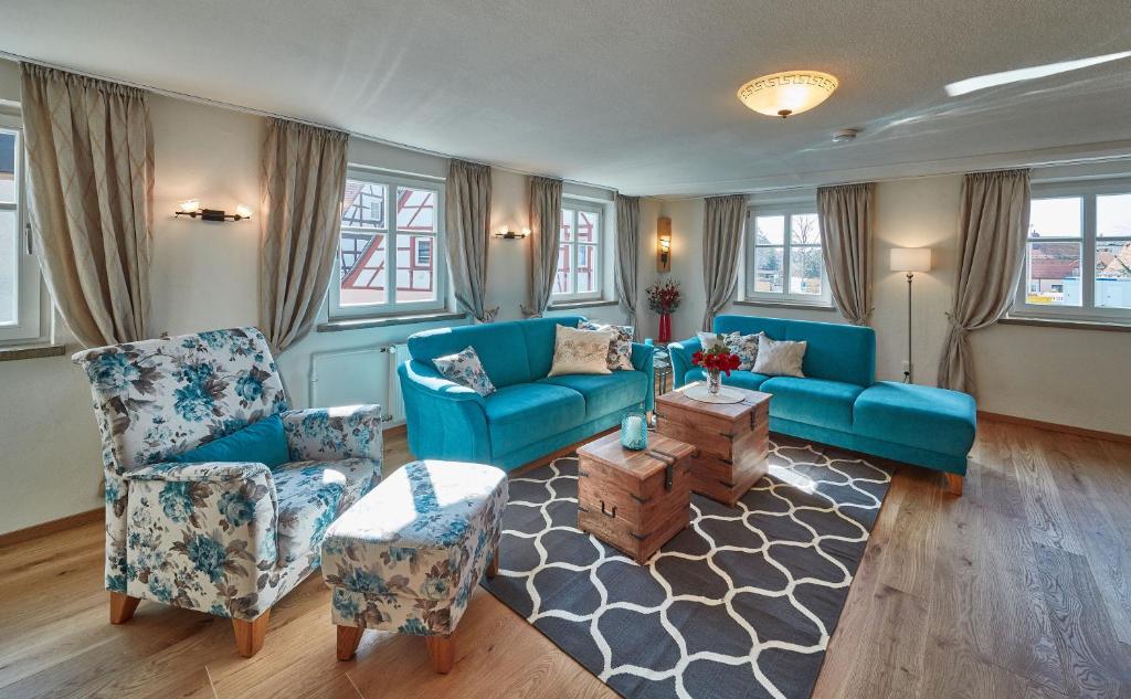 a living room with a blue couch and chairs at Herzo Center Apartments in Herzogenaurach