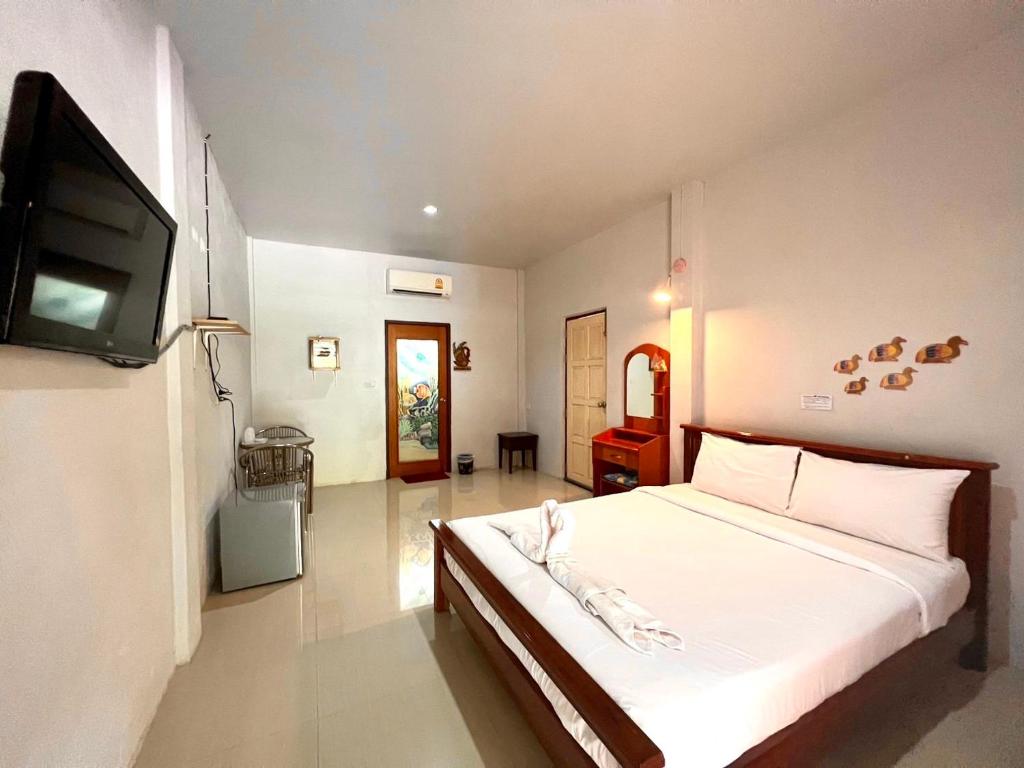 a bedroom with a bed and a flat screen tv at พิณทอง รีสอร์ท in Khlong Thom