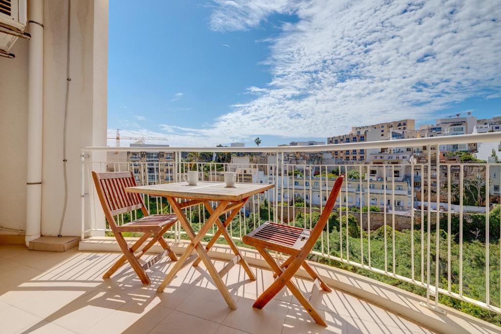 ein Tisch und zwei Stühle auf einem Balkon mit Aussicht in der Unterkunft Modern Apartment steps from Balluta Bay in Sliema