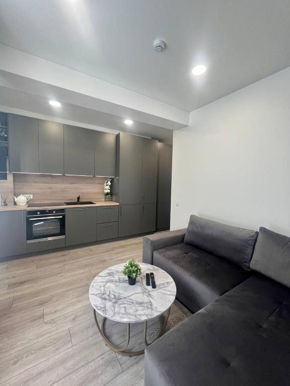a living room with a couch and a table at Apartamentai Sandra in Klaipėda