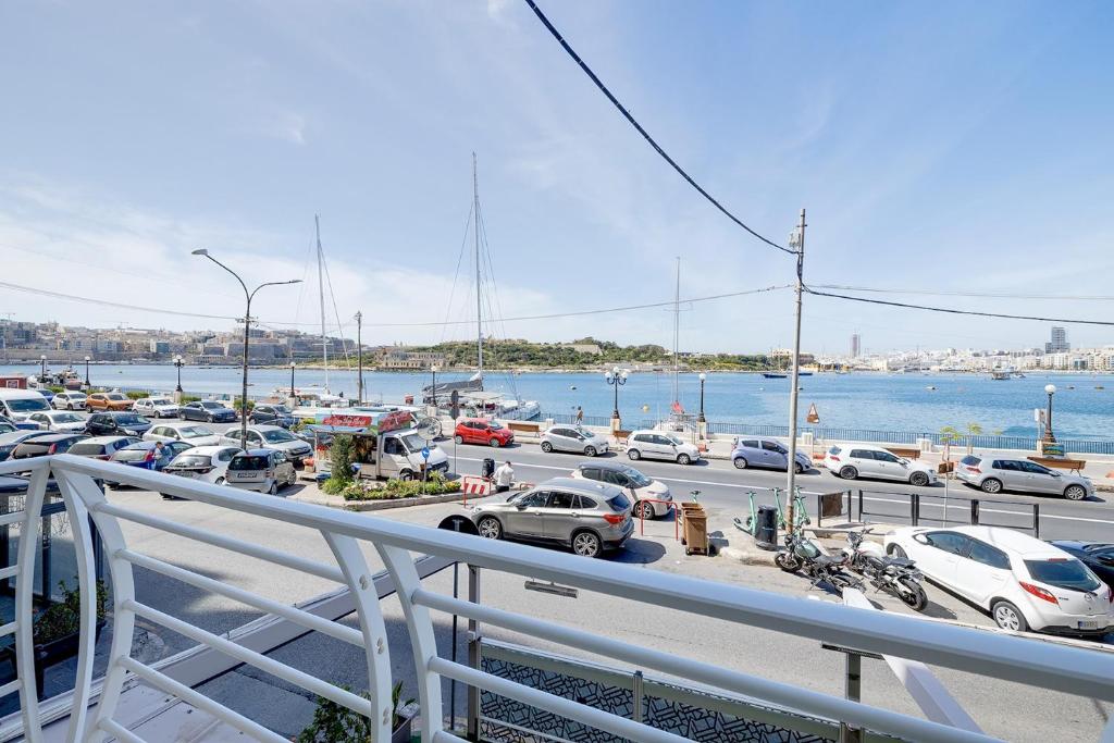 Un parking avec beaucoup de voitures dans un port dans l'établissement Unbeatable Location Valletta and Harbour views, à Sliema