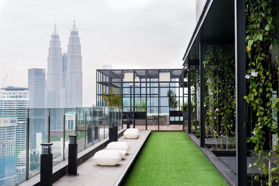 a balcony with green grass and white seats on a building at Majestic Apartment KLCC in Kuala Lumpur