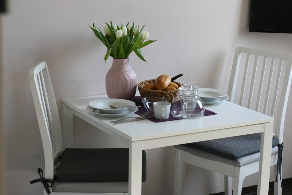 Biały stół z wazą i koszem owoców w obiekcie B-Haus Ueckermünde w mieście Ueckermünde