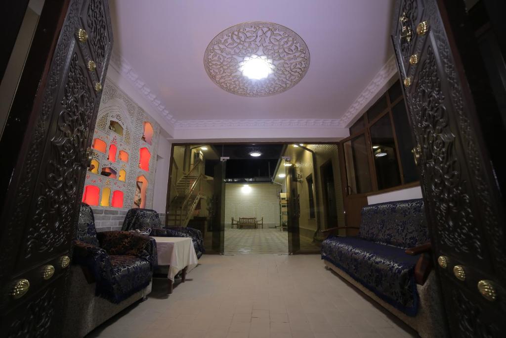 a hallway with chairs and a table and a ceiling at Hotel Hanifa in Bukhara