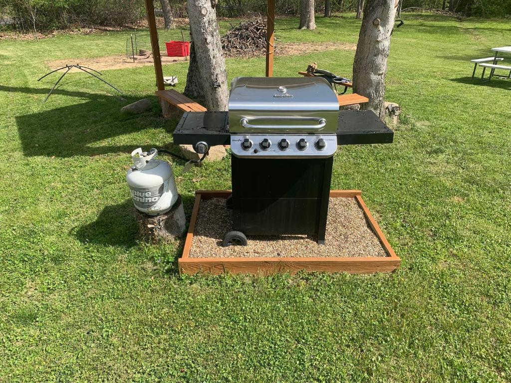 una parrilla sentada en el césped en un patio en Log Cabin in the Field, en Huntington