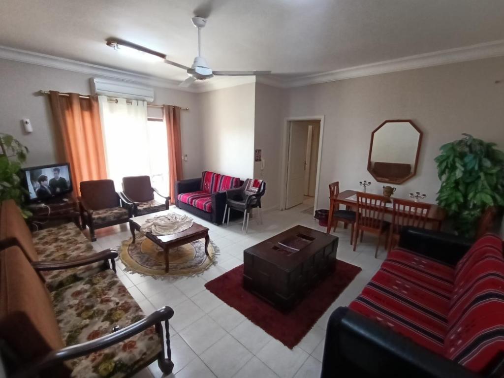 uma sala de estar com um sofá, cadeiras e uma mesa em Sweet aqaba apartment em Aqaba