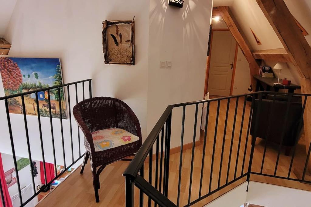 a staircase with a chair and a painting on the wall at Maison périgourdine avec vue et piscine chauffée in Peyzac-le-Moustier