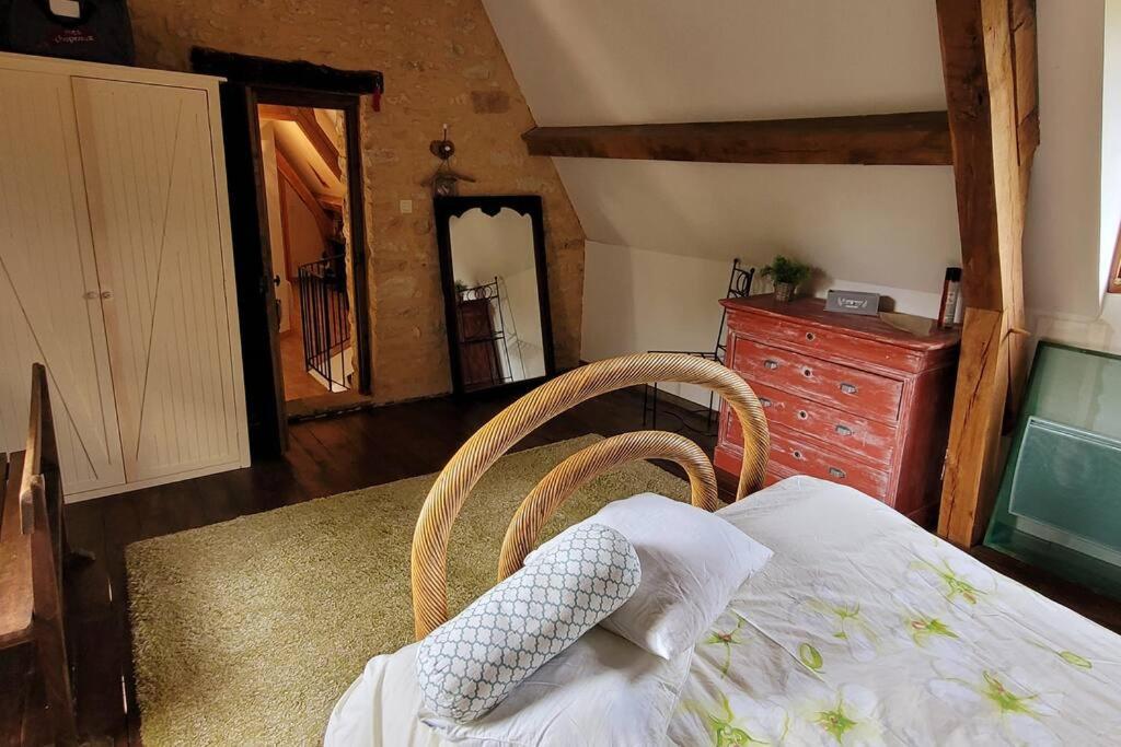 a bedroom with a bed and a dresser and a mirror at Maison périgourdine avec vue et piscine chauffée in Peyzac-le-Moustier