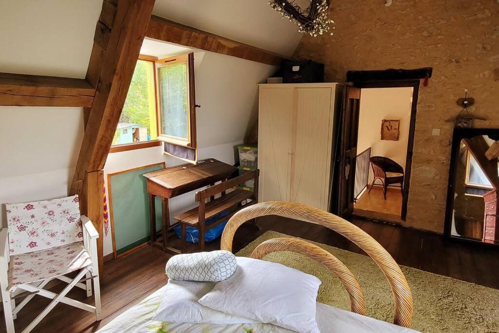 a room with a bedroom with a table and a desk at Maison périgourdine avec vue et piscine chauffée in Peyzac-le-Moustier