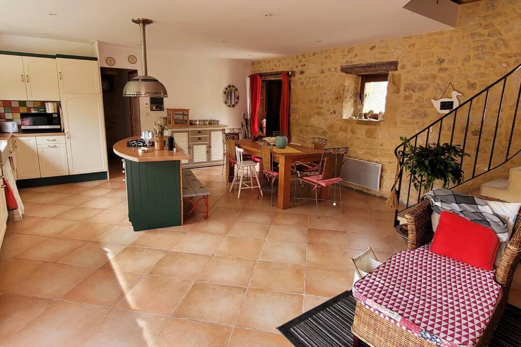 a living room with a kitchen and a dining room at Maison périgourdine avec vue et piscine chauffée in Peyzac-le-Moustier
