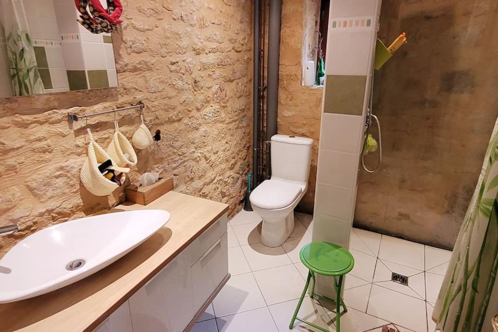 a bathroom with a white sink and a toilet at Maison périgourdine avec vue et piscine chauffée in Peyzac-le-Moustier