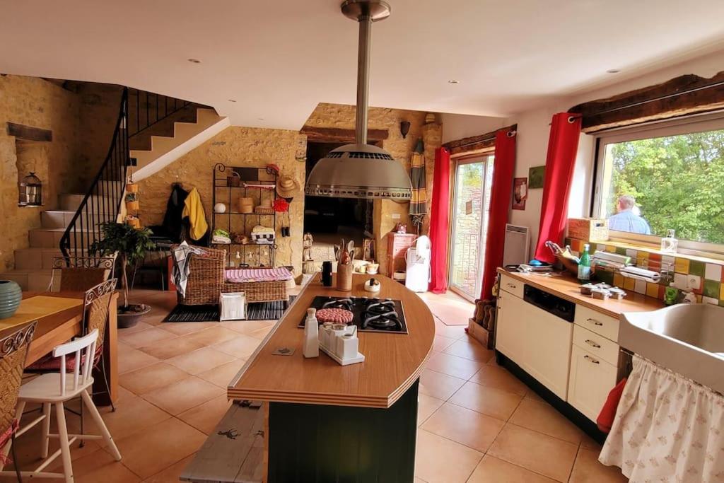 a kitchen with a sink and a stove top oven at Maison périgourdine avec vue et piscine chauffée in Peyzac-le-Moustier