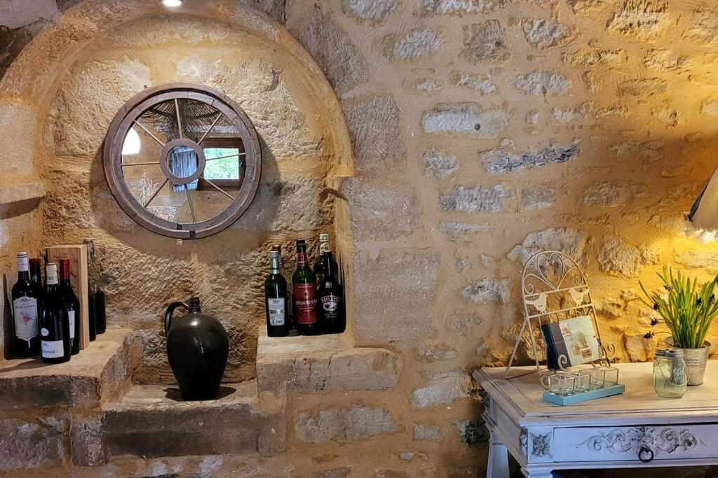a wall with a bunch of bottles of wine at Maison périgourdine avec vue et piscine chauffée in Peyzac-le-Moustier