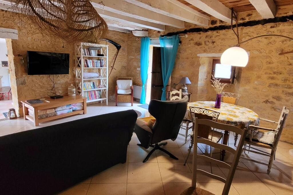 a living room with a couch and a table at Maison périgourdine avec vue et piscine chauffée in Peyzac-le-Moustier