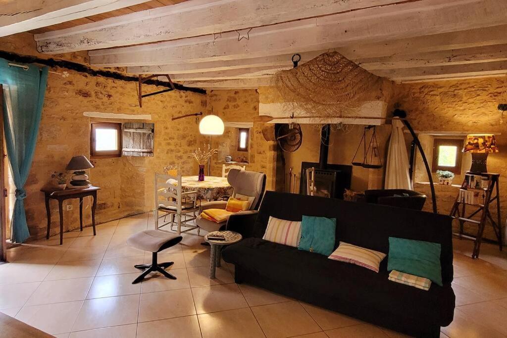 a living room with a couch and a table at Maison périgourdine avec vue et piscine chauffée in Peyzac-le-Moustier