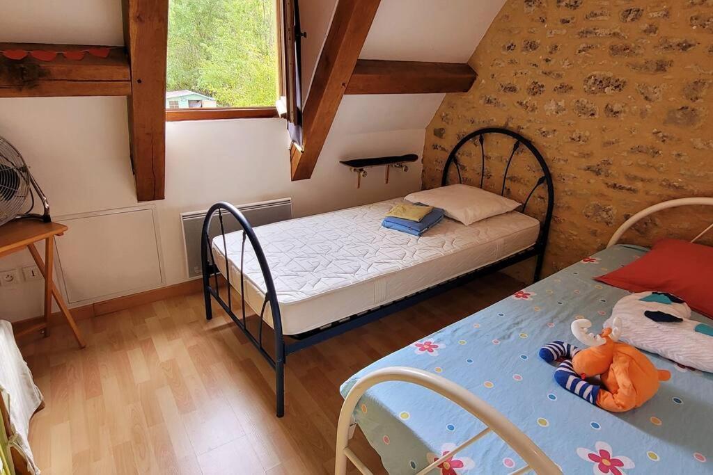 a small bedroom with two beds and a table at Maison périgourdine avec vue et piscine chauffée in Peyzac-le-Moustier