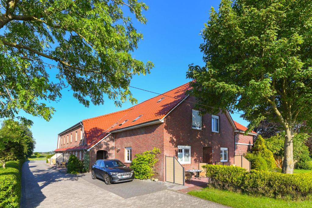 a house with a car parked in front of it at Ferienhof Gerdes in Holtgast
