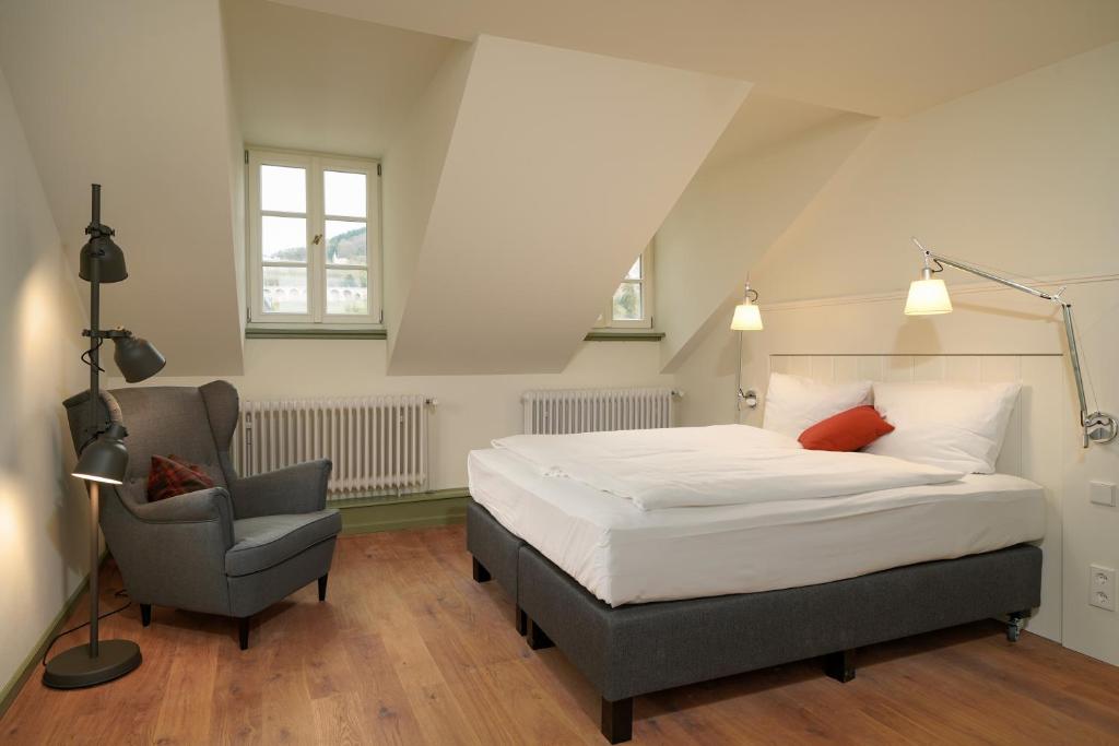 a bedroom with a bed and a chair at Palmbräu Altstadt Appartments in Heidelberg