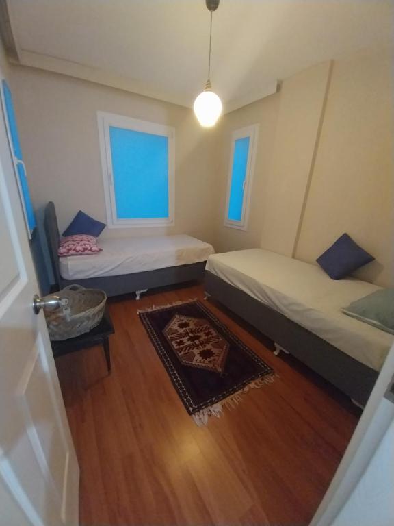 Kleines Zimmer mit 2 Betten und einem Teppich in der Unterkunft Arko sitesi in Karaburun