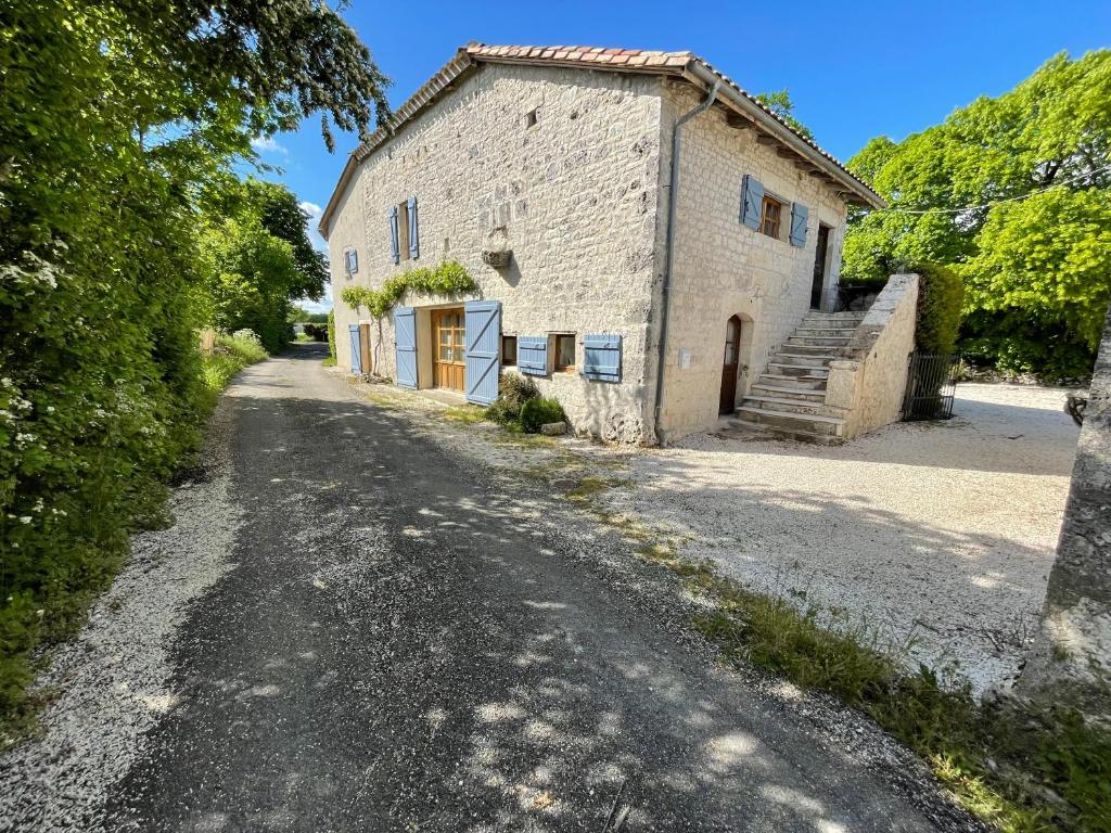 un ancien bâtiment en pierre sur une route en gravier dans l'établissement Bed & Breakfast Elisabeth, à Saint-Matré