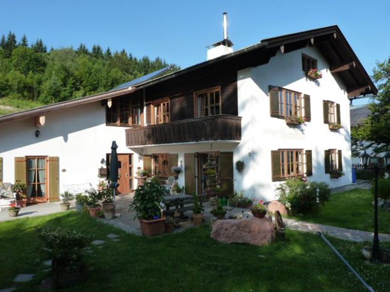 ein großes weißes Haus mit Fenstern und einem Hof in der Unterkunft Landhaus Riemerfeld in Berchtesgaden