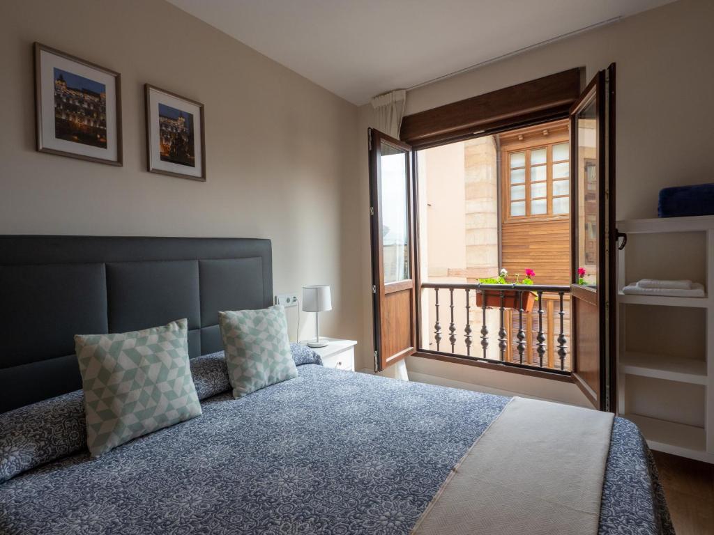 a bedroom with a bed and a window with a balcony at Apartantiguo San Isidoro10 in Oviedo