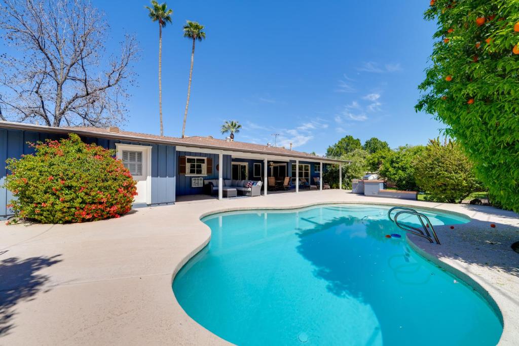 an image of a swimming pool in front of a house at Lovely Phoenix Vacation Rental Home with Pool! in Phoenix