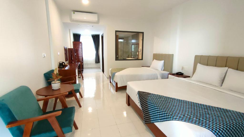 Wildbird Hotel في Tràm Chim: غرفة فندقية بسريرين وكرسي