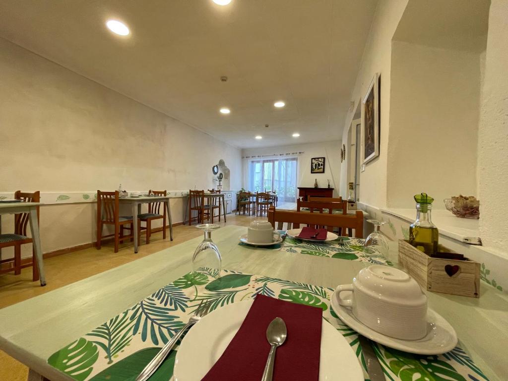 una sala da pranzo con tavolo e piatti di P&R hostals Codolar a Tossa de Mar