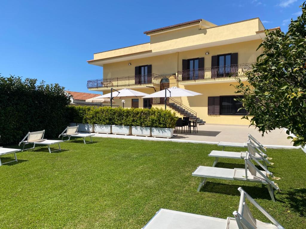 un edificio con un patio con sillas y sombrillas en Villa Cinque en Vico Equense