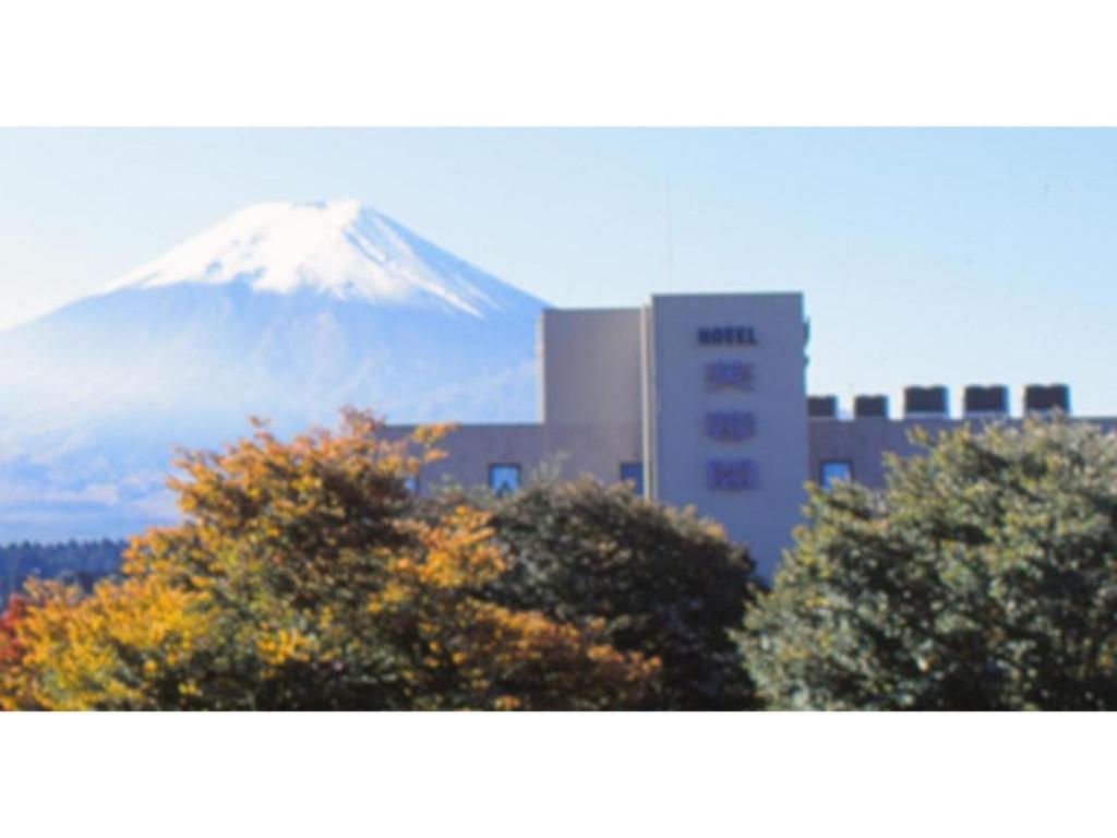 富士吉田的住宿－Hotel Fuyokaku - Vacation STAY 17551v，一座建筑物前的山,树木成荫