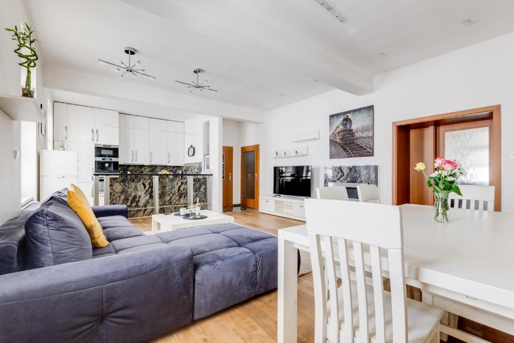 a living room with a blue couch and a kitchen at Luxury & Quiet charming 2bds near river - Nek2nd in Prague