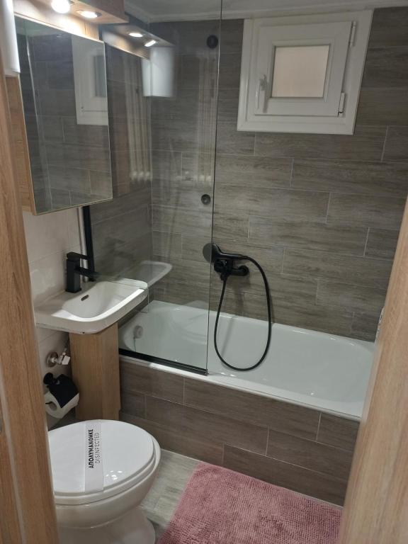 uma casa de banho com um chuveiro, um WC e um lavatório. em Central 4 Modern Apartment with parking em Serres
