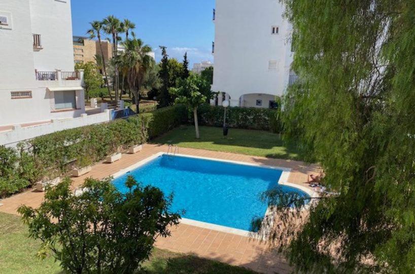 a swimming pool in a yard next to a building at Los Girasoles in Marina Botafoch in Ibiza Town