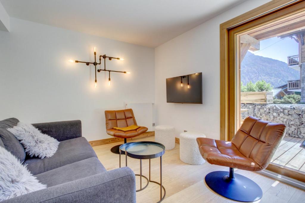 un salon avec un canapé, des chaises et une fenêtre dans l'établissement Frenes Hauts 002 deux pieces cabine pour 4 6 personnes au pied des pistes du Pleney, à Morzine