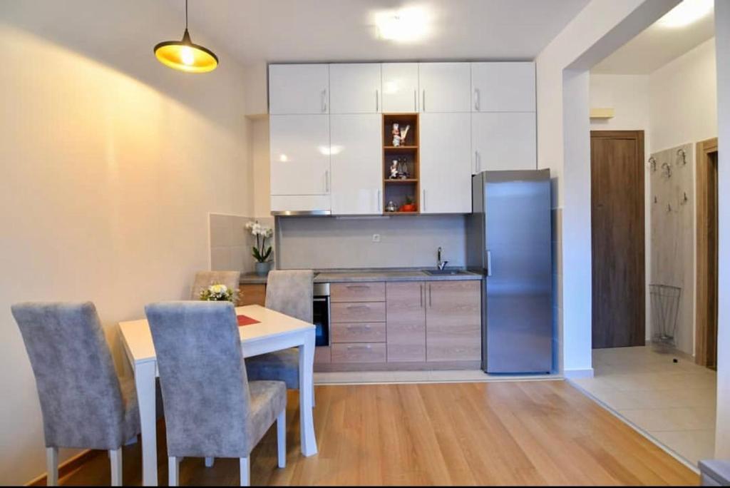 een keuken met een tafel en een koelkast bij Apartman Ana in Herceg-Novi