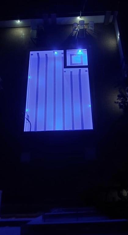 een podium met een blauw licht in het donker bij Море Песок in Antalya