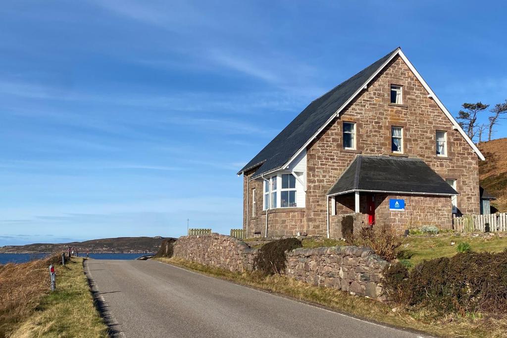 ゲイロックにあるGairloch Sands Youth Hostelの道路脇石造りの家