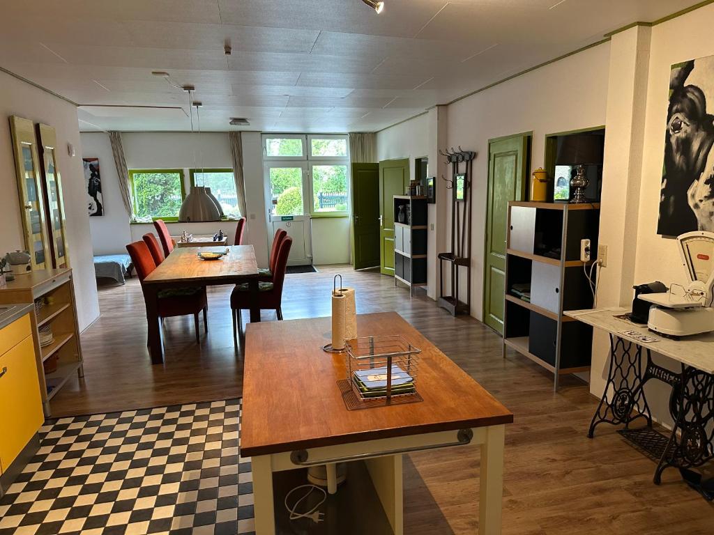 cocina y sala de estar con mesa y sillas en Het Melkhuis op prachtig Landgoed Koepeltjesplaats, en Gaast