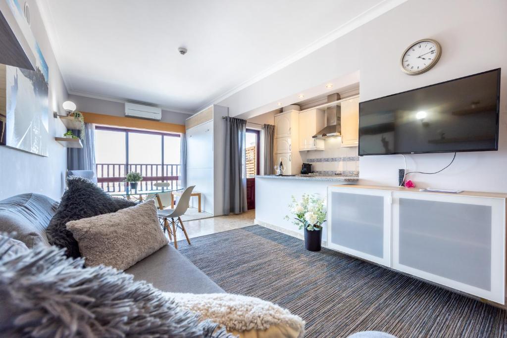 a living room with a couch and a kitchen at Clube Praia Mar Flat T1 in Portimão