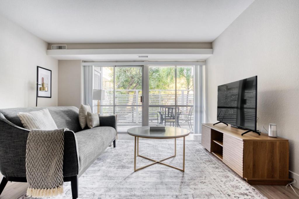 a living room with a couch and a tv and a table at Sunnyvale 1BR w WD Gym Pool nr FB Google SFO-730 in Sunnyvale