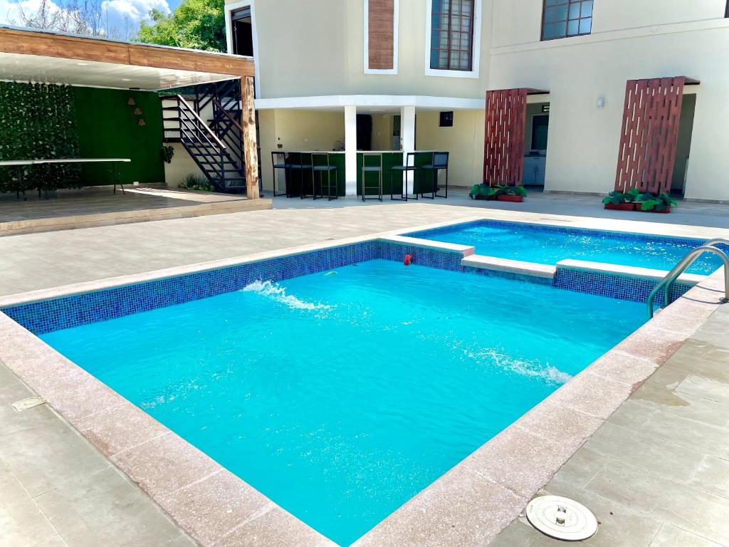 a swimming pool with blue water in front of a house at Villa Marot Eventos 