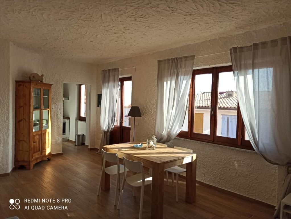 羅薩島的住宿－Il Maestrale，一间带桌子和一些窗户的用餐室