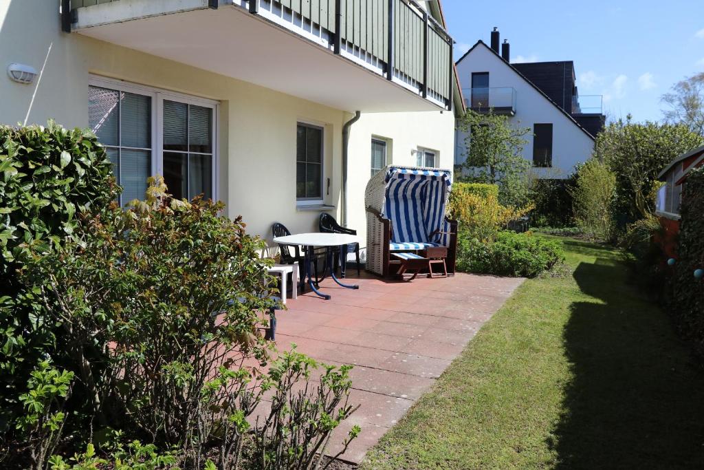 a patio with a table and chairs next to a house at Altes Wasserwerk App 10 in Wustrow