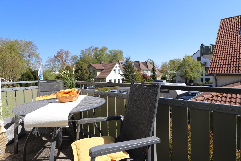 Un patio con una mesa y sillas en un balcón. en Altes Wasserwerk App 13, en Wustrow
