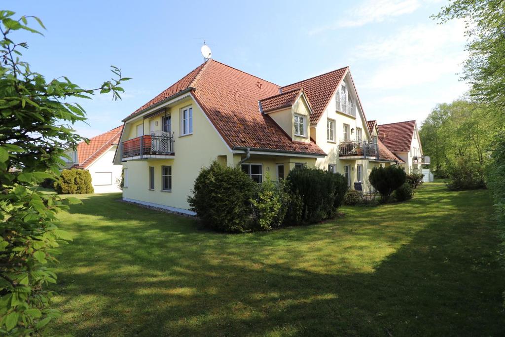 a large white house with a yard at Wohnpark Schmiedestraße App 03 in Wustrow