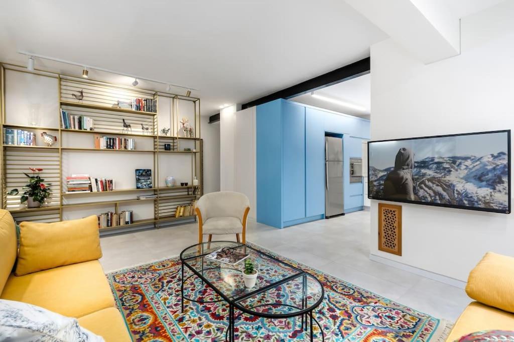 sala de estar con sofá y mesa de cristal en Two bedrooms flat with garden and free parking, en Tel Aviv